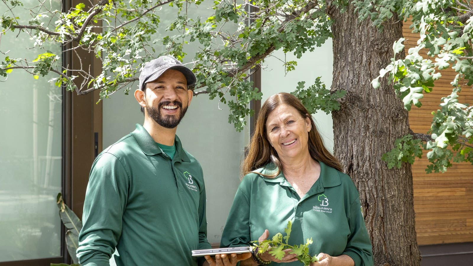Benjamin's Tree Service crew reviewing an emergency tree service estimate on a tablet at a Las Vegas home